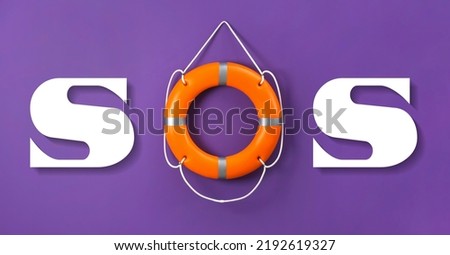 SOS message made from lifebuoy and white letters on violet background Royalty-Free Stock Photo #2192619327
