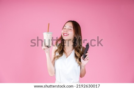 Asian woman girl drinking bubble milk tea excited emotion and holding smart phone, Food and drink delivery concept on the pink background Royalty-Free Stock Photo #2192630017