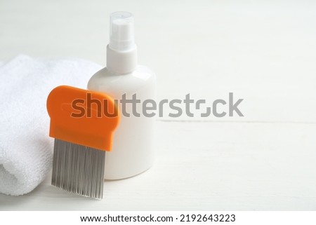 Comb, anti lice spray and towel on white table. Space for text