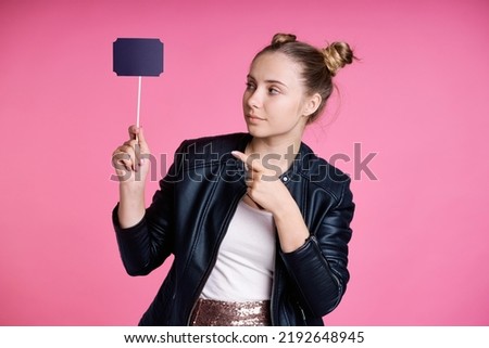 Caucasian teenage girl holding and pointing on held thought bubble