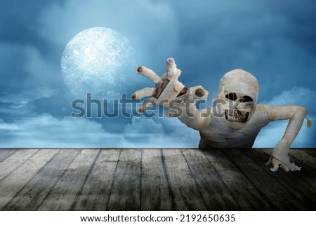 Mummy with skull head crawling with a night scene background. Halloween concept