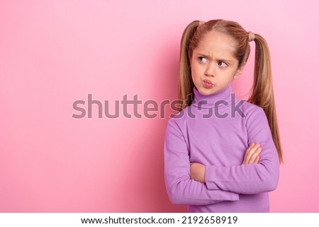 Picture of young charming thoughtful little girl look empty space brainstorming isolated on pink color background