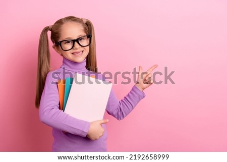 Photo of young adorable charming little girl promote her school hold copybooks isolated on pink color background