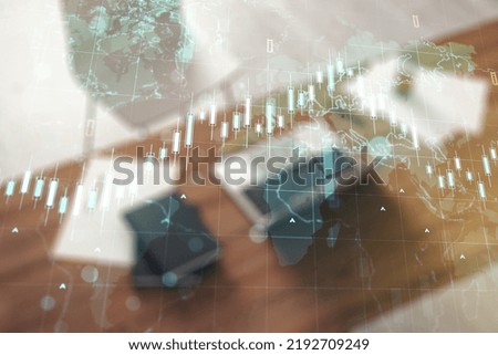 Double exposure of abstract creative financial diagram with world map and modern desk with computer on background, banking and accounting concept