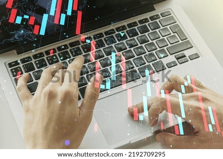 Creative abstract economic crisis chart with world map hologram and with hands typing on computer keyboard on background, bankruptcy and recession concept. Multiexposure