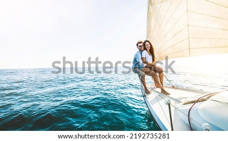 Young couple relaxing on yacht cruise - Two lovers enjoying summer vacation experience on sail boat at the sea - Summertime holidays and luxury travel concept Royalty-Free Stock Photo #2192735281