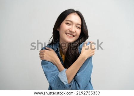 Self care and self esteem concept, Happy young beautiful woman hugging herself isolated on the background Royalty-Free Stock Photo #2192735339