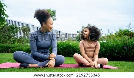 Mindful african mom with cute kid daughter doing yoga exercise outdoor.calm black mother and talking little girl sitting in lotus pose on couch together, mum teaching child to meditate. Royalty-Free Stock Photo #2192735345