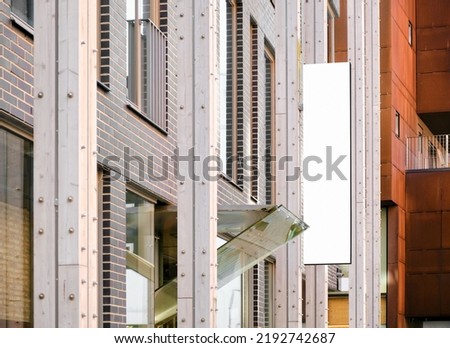 Vertical modern shop signage on modern building wall, empty business sign outdoors