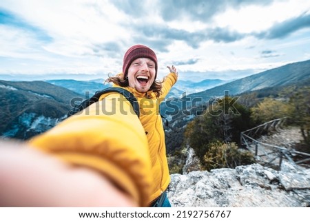 Happy hiker taking selfie on the top of the mountain - Young man having fun on weekend activity outside - Travel blogger on social media live show 
