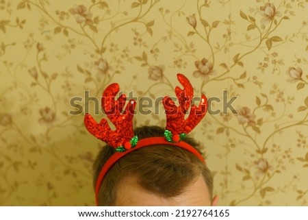 Red deer's horns Christmas headband on a man's head. Christmas. Cute. Design. Accessory. Festive. Carnival. Element. Decoration. New Year. Tradition. Cartoon
