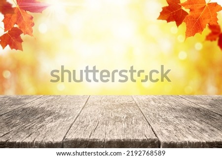 Autumn background with maple leaves and empty wood shelf. Fall background with copy space for product display.