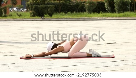 Photo of young amazing sports black woman make stretching exercises outdoors on the street.