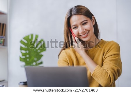 Asian businesswoman talking on smartphone and working in office Asian businesswoman sitting at his office