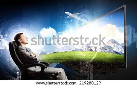 Young businessman sitting in chair behind tv
