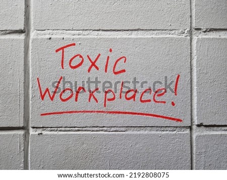 Toxic workplace words handwritten on the wall. Royalty-Free Stock Photo #2192808075