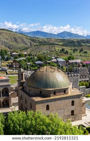 Akhmediye Mosque building with golden dome in Akhaltsikhe (Rabati) Castle courtyard, medieval fortress in Akhaltsikhe with Akhaltsikhe village and Lesser Caucasus mountains in the background. 