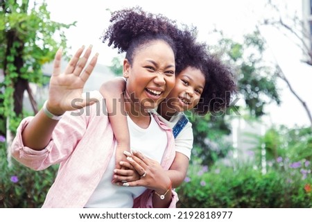 Portrait of young woman and mother with bright smiling in the garden middle of cityscape. Family and love concept