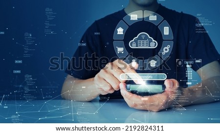 A person is connecting to the Internet through a smartphone to access cloud computing technology that has cybersecurity protection to protect user data. small binary code polygon on blue background. Royalty-Free Stock Photo #2192824311