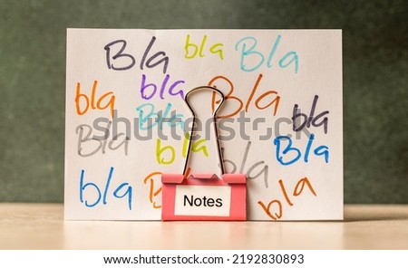 Bla, bla, bla written on a note, held upright by a binder clip. Royalty-Free Stock Photo #2192830893