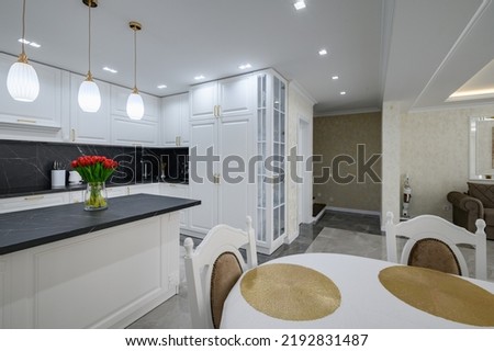 Luxurious white modern domestic kitchen with black marble worktop Royalty-Free Stock Photo #2192831487