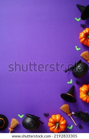 Happy Halloween holiday concept. Halloween decorations, pumpkins, bats, spiders and witch's pots, hats, brooms on purple background. Halloween party greeting card mockup with copy space. Flat lay, top