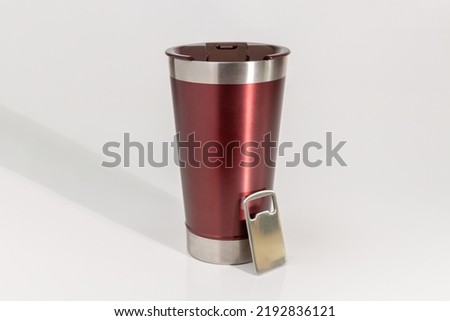 Wine-colored thermal glass with opener. White background and front view. Space for text.