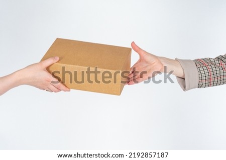Cardboard box in hand. Transferring package from one person to another. Box without inscriptions on white. Concept of targeted delivery. Courier delivery in person. Place to write on box Royalty-Free Stock Photo #2192857187