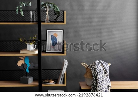 interior and home decor concept - book shelf with art and decorations over black background
