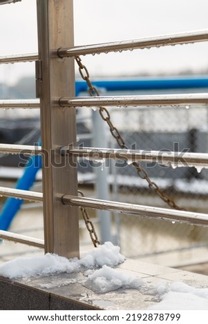 handrail, railing with water drops and wet snow build-up. early spring weather conditions, thaw and snow melting Royalty-Free Stock Photo #2192878799