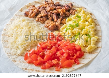 Taco with chipotle chicken, tomato, cheese and eggs