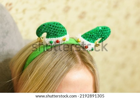 Green elf's hat Christmas headband on a woman's head. Object. Event. Fashion. Shape. Flat. Celebrate. Style. Decorative. Set. Santa. Festival. Winter. Elegance