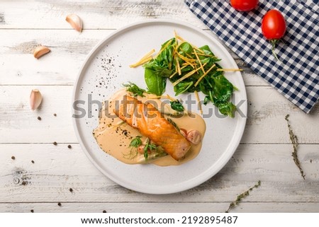 Salmon steak on the grill with spinach on white plate on white wooden table top view Royalty-Free Stock Photo #2192895487