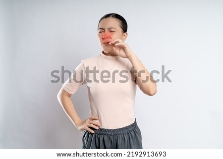 Asian woman was sick with fever, sneezing and rubbing her nose with red spot, standing isolated on white background. Royalty-Free Stock Photo #2192913693
