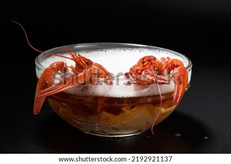 Boiled red crayfish - an appetizer bathed in beer like in a sauna or bubble bath, creative funny photo Royalty-Free Stock Photo #2192921137