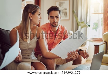 Unhappy, stressed and upset couple paying bills or debt online on with a laptop at home getting angry, planning budget. Young man and woman having a dispute over finance, savings and increasing tax Royalty-Free Stock Photo #2192921379