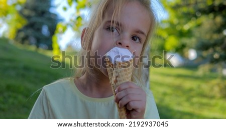 European blonde girl eating ice cream on a sunny day