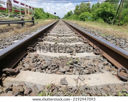 Picture of straight train tracks There is a cement core as a support. and has a stone to support the weigh