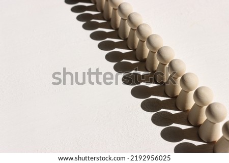 Concept image of wooden figures forming a wall. Leadership teamwork and strength metaphor