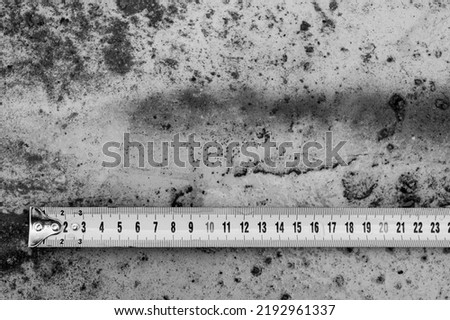 Measuring ruler on a concrete wall texture. The concept of renovation, repair or construction.