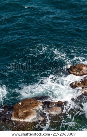 rocks in the sea. waves crashing the shore. water and stone texture. summer nature background