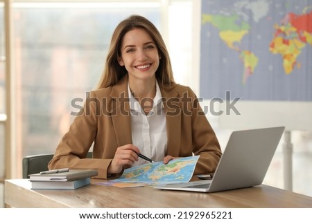 Travel agent with world map at table in office Royalty-Free Stock Photo #2192965221