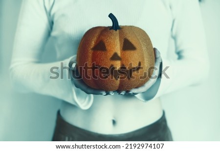 The witch holds Jack Lantern's head in her hands. A young girl holds a horrible pumpkin with a smiling face for Halloween on the eve of All Saints' Day. A woman holds a creepy pumpkin. Postcard design
