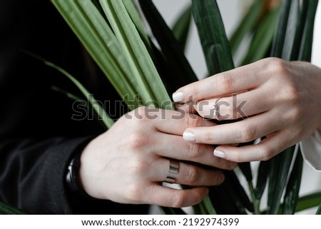LGBTQ concept, female hands tenderly and gently holding each other's hands. Silver rings, engagement. Love and care concept