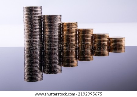 Coins are stacked in layers arranged from small to large. Stacking coins on white background, Money growing concept.
