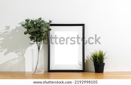 Style picture frame still life put on the wooden table. Blank space empty picture frame with mockup. Shot in studio with natural light. Template background interior design and decoration.
