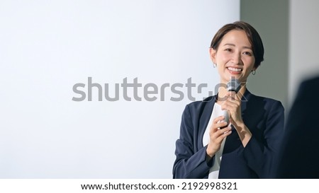 Asian middle aged woman giving a lecture and audience. Royalty-Free Stock Photo #2192998321