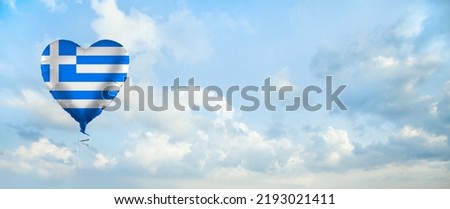 Greek flag on balloon against sky clouds background. Education, charity, emigration, travel and learning Greek language, Greece concept