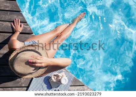 Woman on wooden deck near swimming pool. Summer vacation