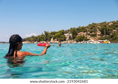 Happy young couple playing with a plastic disc in the sea. Travel, vacation and fun